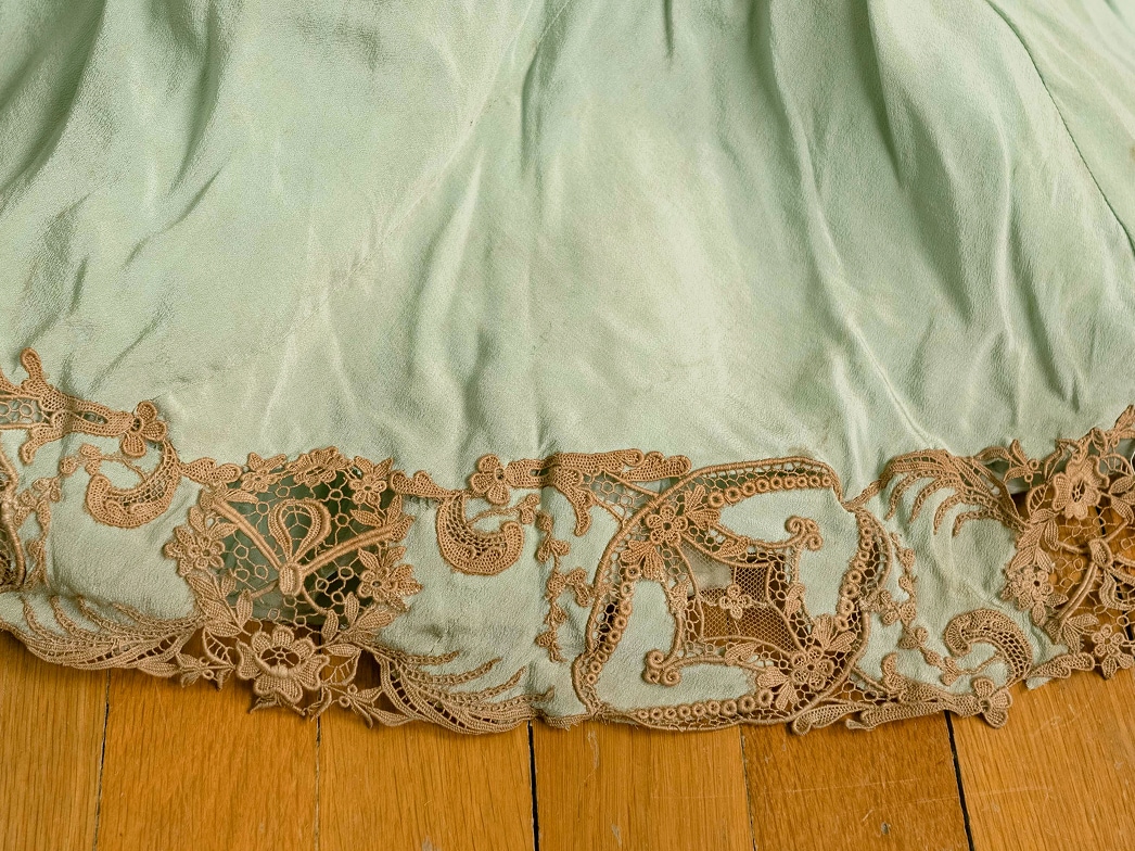 Le bas d’une robe en soie est orné d’appliqués de dentelle sur les bords de la soie.