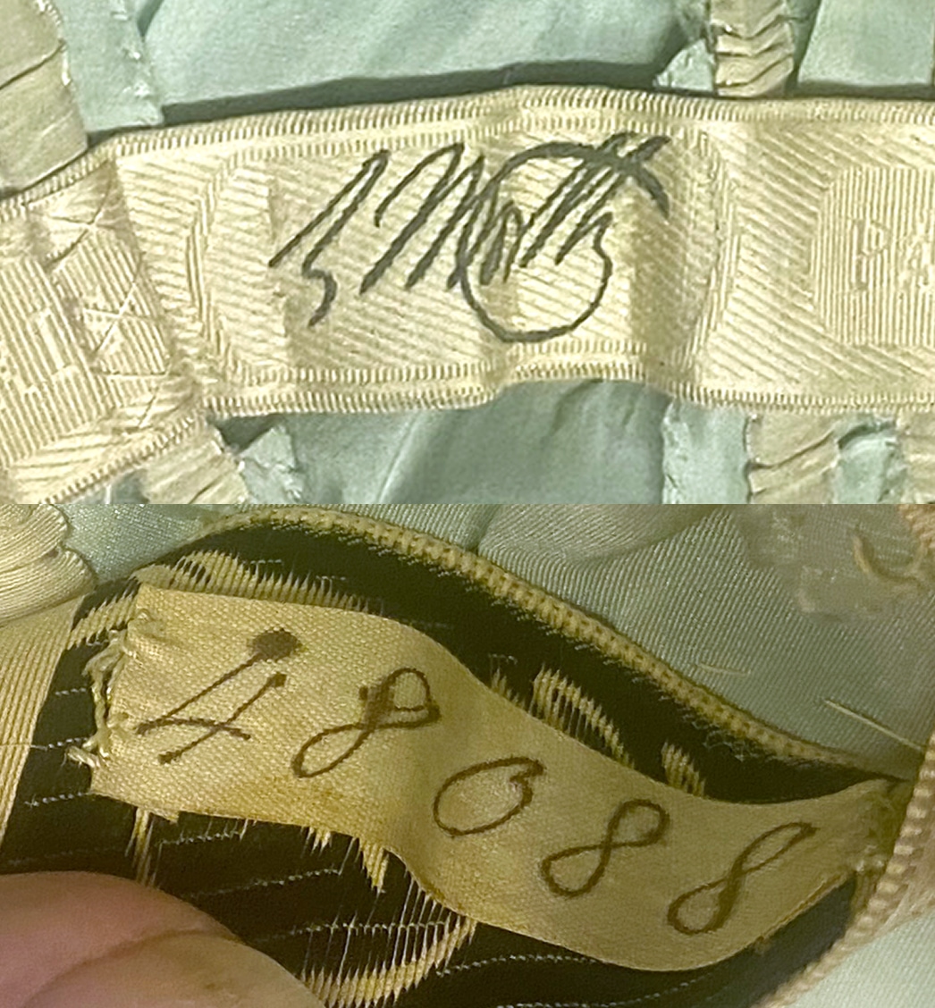 Un gros plan de l’étiquette de la marque à l’intérieur d’une robe montre la signature de Worth tandis que le dessous de l’étiquette affiche le numéro 48088.