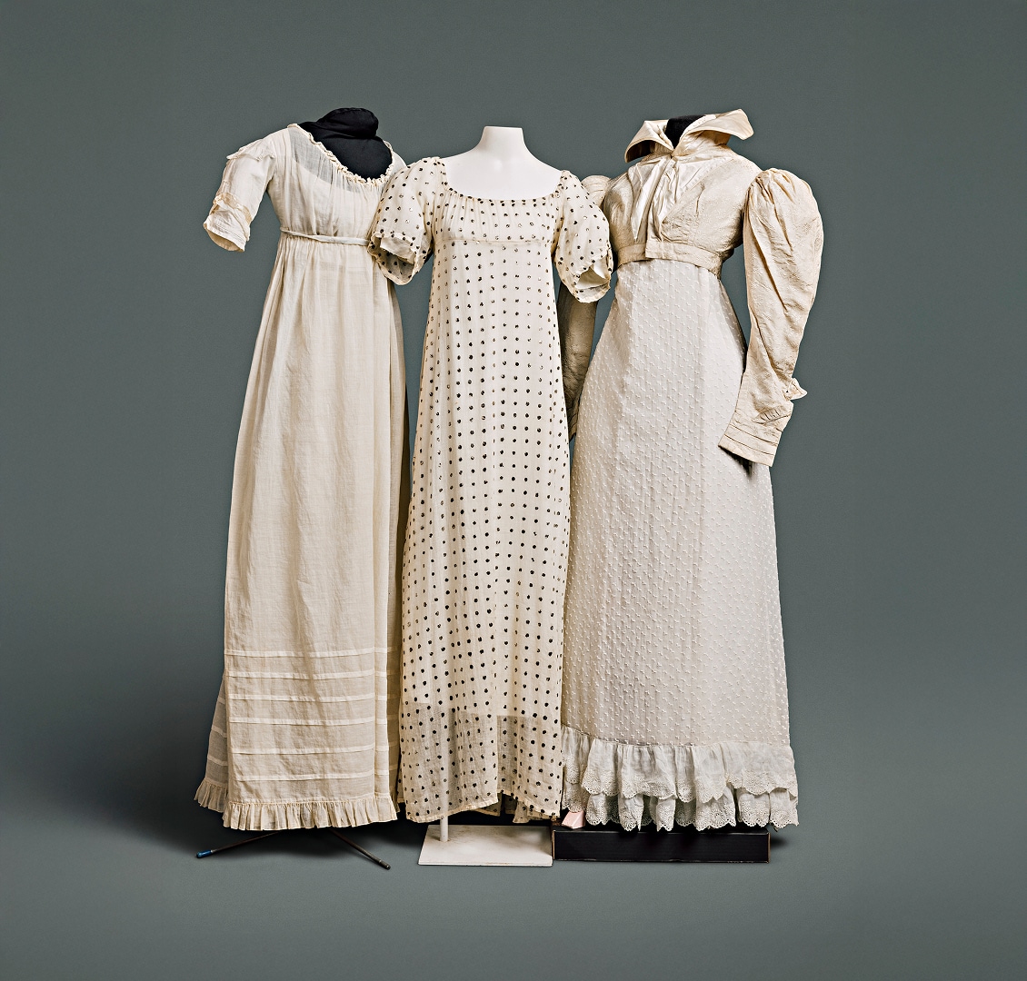 Trois robes en coton aux motifs simples et aux manches s’arrêtant juste au-dessus du coude. L’une des robes est accompagnée d’une veste Spencer en coton à col montant.
