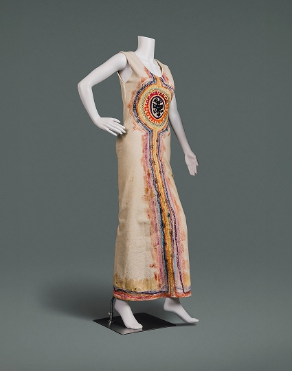 Une robe longue en coton naturel ornée de peintures et de broderies inspirées des traditions de l’art populaire.