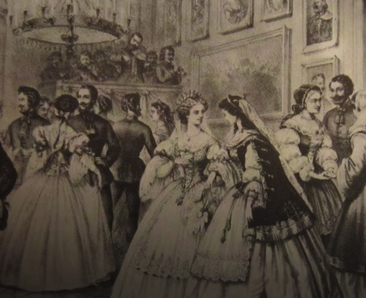 Des dames en élégantes robes d’époque côtoient des messieurs en uniformes militaires lors d’un bal aristocratique. Un petit orchestre joue en fond sonore.