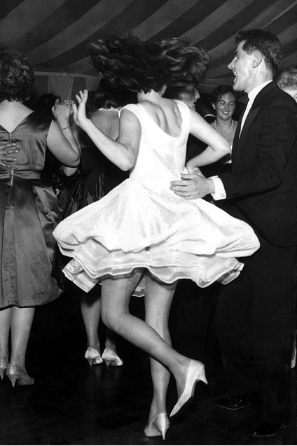 Une femme, les cheveux défaits, danse sur de la musique des années soixante, sa jupe s’évasant de tous côtés.