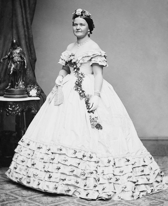 La Première dame, Mary Todd Lincoln, dans une robe de bal ornée d’une guirlande de fleurs.