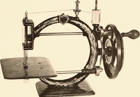 Une machine à coudre vintage avec manivelle et corps en forme de croissant.