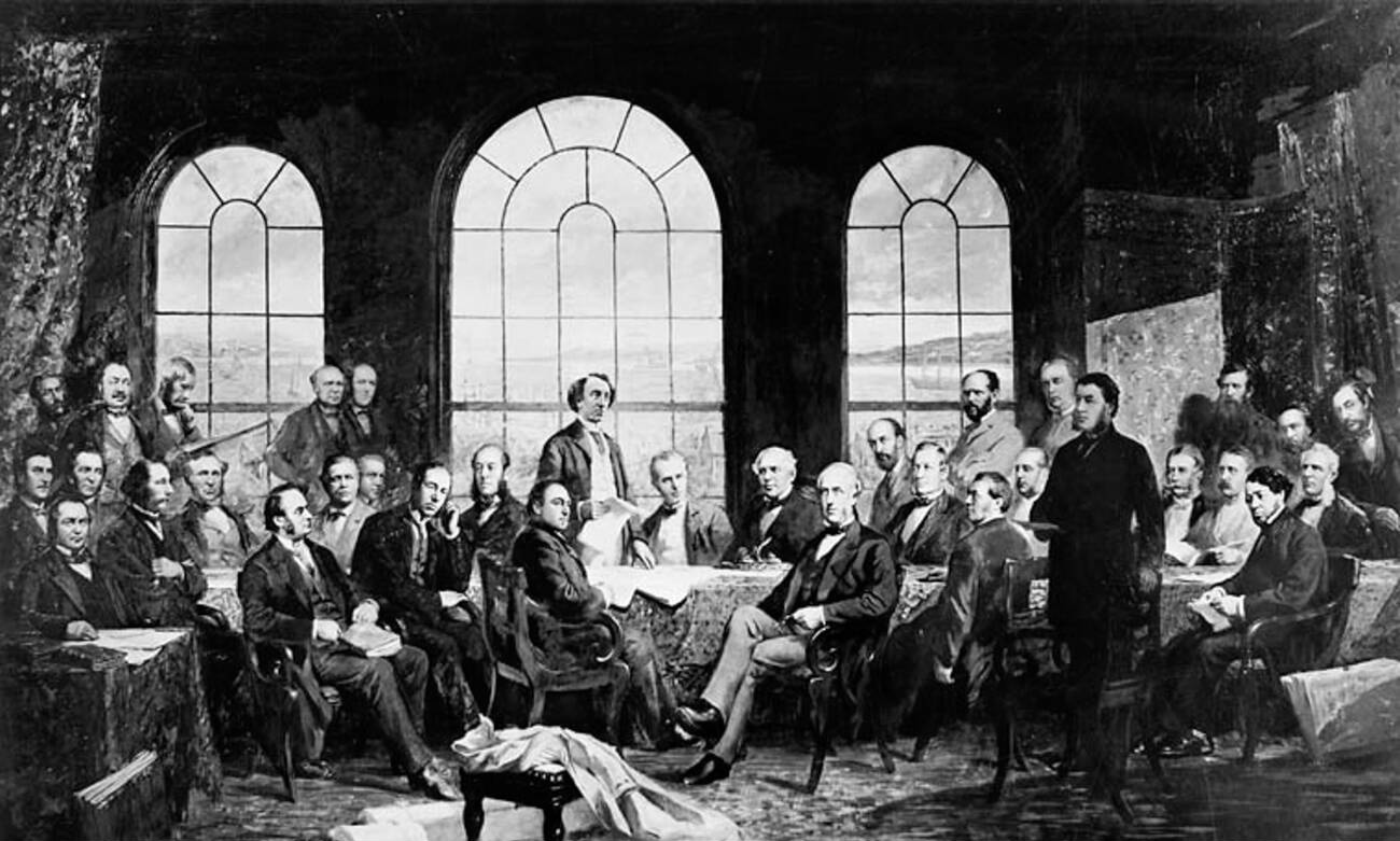 Portrait des Pères de la Confédération, avec John A. McDonald au centre. Les 37 hommes sont assis et debout autour d’une grande table, derrière laquelle se trouvent trois grandes fenêtres cintrées. À l’extérieur, on aperçoit des bateaux sur le fleuve Saint-Laurent.